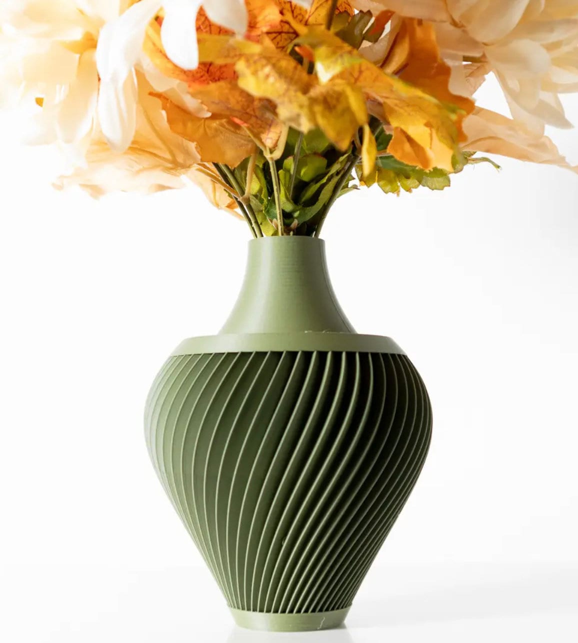 A contemporary ribbed vase in a soft green, showcasing a lush arrangement of autumn flowers, set against a serene backdrop, perfect for enhancing any home or office space.
