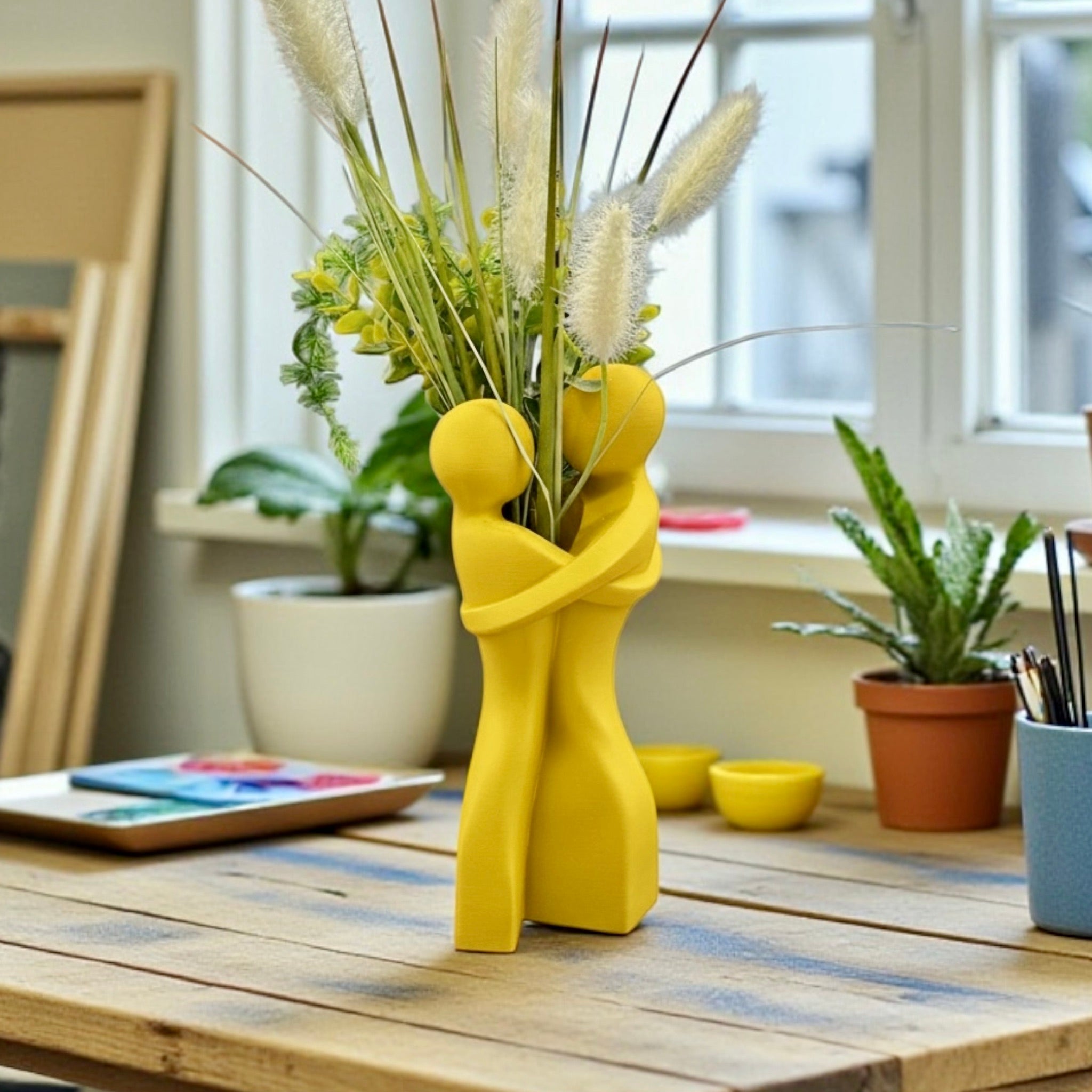 Yellow Embrace Vase styled with dried botanicals – figural love symbol decor